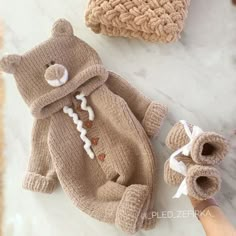 a teddy bear sweater and booties on a marble surface