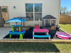 some chairs and umbrellas in front of a house with a doghouse on the other side