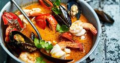 a bowl filled with seafood and mussels on top of a table