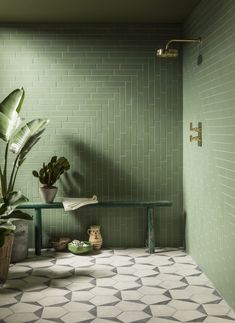 a green tiled bathroom with potted plants