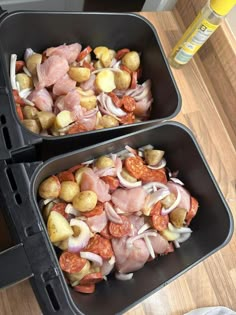 two pans filled with food sitting on top of a wooden table