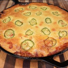 a baked dish with zucchini and cheese in a skillet on a wooden table