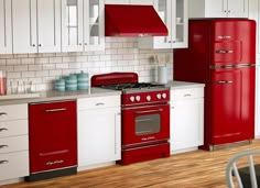 a red stove top oven sitting inside of a kitchen next to a white refrigerator freezer