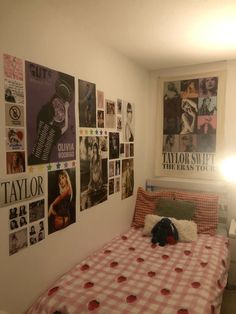 a bed sitting in a bedroom next to a wall with pictures on it