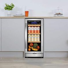 an image of a beverage cooler in the middle of a kitchen with fruits and vegetables