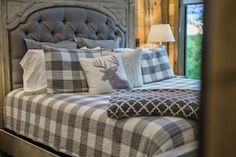 a bed with plaid sheets and pillows in a bedroom