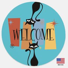 a welcome sign with two black cats on it