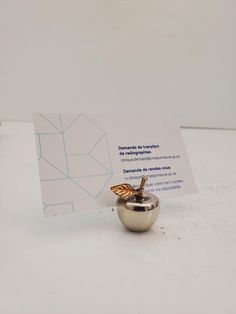 a small silver apple with a business card in it