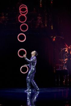 a woman juggling some hoop rings on stage