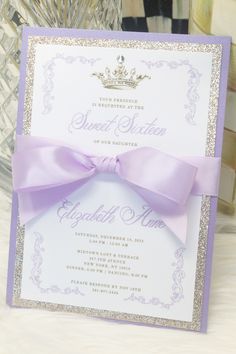 a purple and silver wedding card with a bow