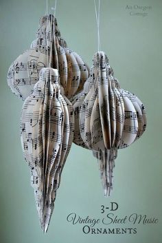 an ornament made out of sheet music is hanging from strings with musical notes