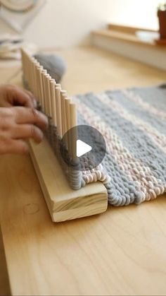 a person is weaving on a wooden board