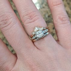 a woman's hand with two rings on top of her ring and the middle one is