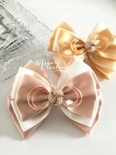 two bows with pearls on them sitting next to each other