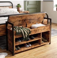 a wooden bench with shoes on it in front of a bed