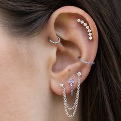 a woman's ear with three different piercings