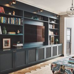 a living room with built in bookshelves and a television on top of it