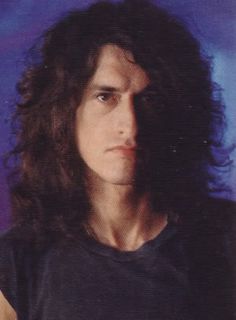 a man with long hair wearing a black shirt