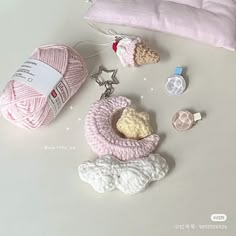 some crochet items are laying out on the table next to a ball of yarn