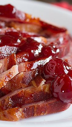 slices of bacon and jelly on a white plate with ketchup drizzle