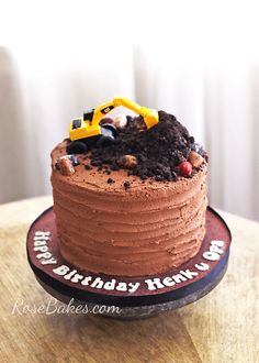 a chocolate birthday cake with a construction truck on top that says happy birthday kenk - u - go