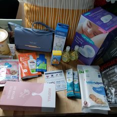 the contents of a diaper bag laid out on a table next to other items