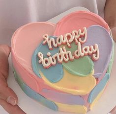 a heart shaped cake with the words happy birthday on it being held by someone's hands