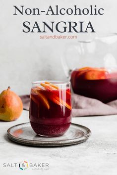 two glasses filled with sanggraa sitting on top of a plate next to an orange