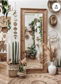 a mirror sitting on top of a wooden floor next to potted plants and other decorations