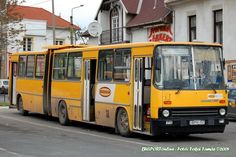 a yellow bus is parked on the side of the road in front of some buildings