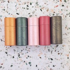 four different colored flasks sitting on top of a countertop next to each other