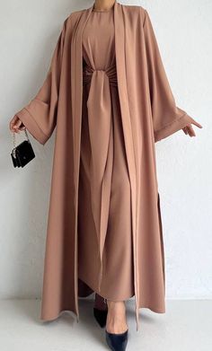 This chic abaya set has a sleeveless inner maxi with a stylish tie belt in front and a detached matching open abaya to complete the trendy look. Chic Abaya, Open Kimono, Stylish Maxi Dress, Fashion Show Dresses, Modest Casual Outfits, Colorful Maxi Dress, Open Abaya, Chic Maxi Dresses, Cotton Kurti Designs