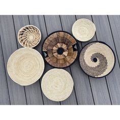 several woven baskets are arranged on a wooden floor with black and white trimmings