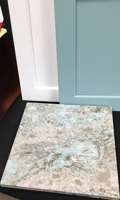 a blue door next to a gray and white marble counter top in front of a light blue door