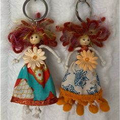 two key chains with dolls on them sitting next to each other