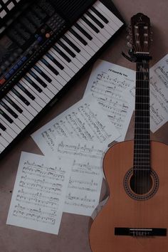 an ukulele and sheet music sit on the floor next to a piano keyboard