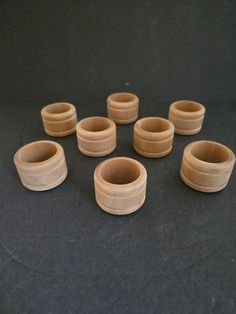 six wooden bowls sitting on top of a black table next to each other and one is empty