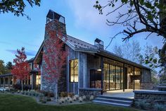 a stone building with glass windows and stairs leading up to the front door at dusk