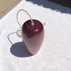 a red lamp sitting on top of a table next to a white cloth covered ground