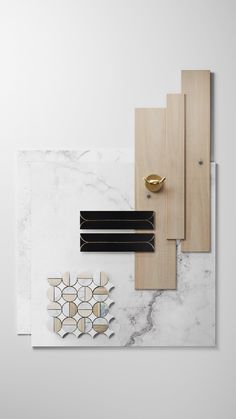 an assortment of wood and marble pieces on display in a white room with gold accents