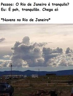 there are clouds in the sky above some buildings and cars on the road below them