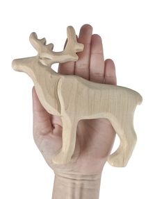 a hand holding a small wooden deer ornament