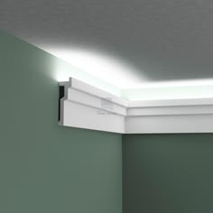 a white light that is on the side of a wall in a room with green walls