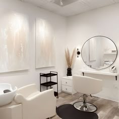 a salon with white furniture and mirrors on the wall