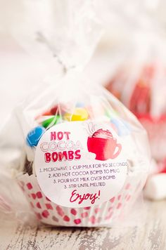 a cupcake wrapped in plastic sitting on top of a wooden table next to candy