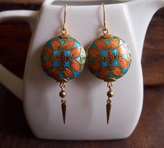 Beautiful cloisonne enamel earrings depicting an Arts and Crafts / William Morris inspired circlet of leaves accented with dainty brass beads and brass spike drops. These gorgeous and unique vintage beads are finished off with dainty brass drops. So eye-catching and elegant, they make the perfect gift for any lover of historical or classic art and design. You'll find them to be surprisingly lightweight, as they're hollow!  Looking for more cloisonne earrings? click here: https://www.etsy.com/ca/ Bohemian Gold Enamel Earrings, Oddities Jewelry, William Morris Inspired, Miss Fisher, Cloisonne Earrings, Chit Chat, Earrings Art, Brass Beads, Enamel Beads