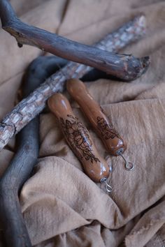 two wooden spoons sitting on top of a bed next to a twig and branch