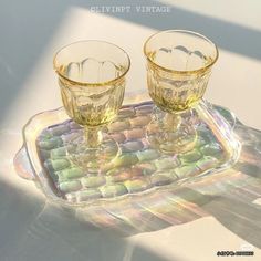 two glasses sitting on top of a glass tray