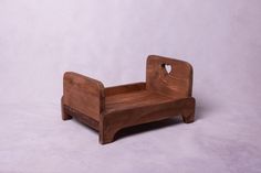 a wooden toy bed sitting on top of a white floor