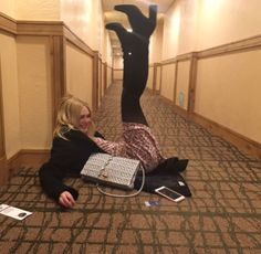 a woman laying on the floor with a laptop in her hand and an upside down photo